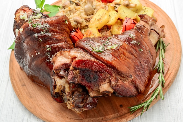 Foto stinco di maiale arrosto con verza e patate al forno