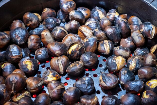 Photo roasting chestnuts in a special pan over an open firetypical food in spain during the festival of all saints