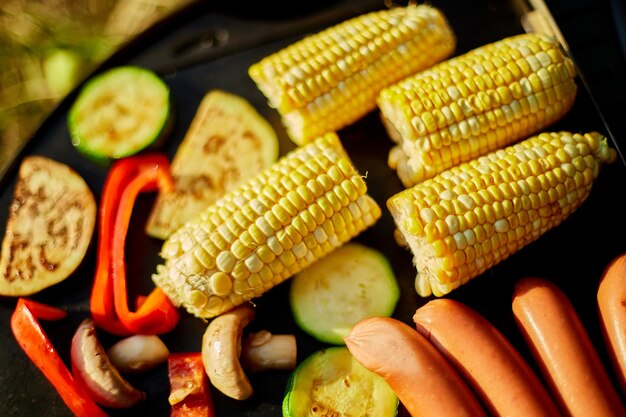 Roasting vegetables and vegan sausages on the barbecue gas grill outdoor in the backyard Vegetables On Grill summer family picnic food on the nature