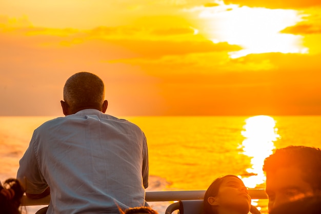 Roatan, Honduras: Een man die naar de zee kijkt bij zonsondergang op de veerboot naar Roatan Island