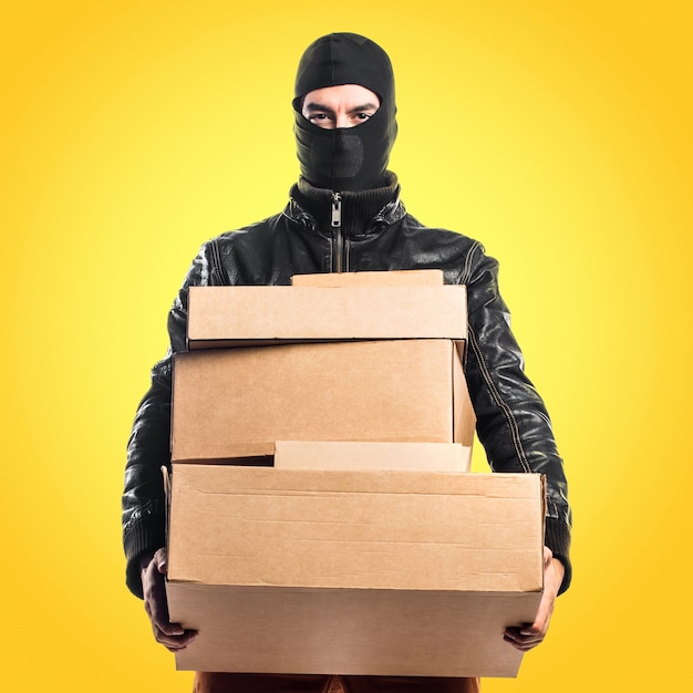 Robber holding boxes on colorful background