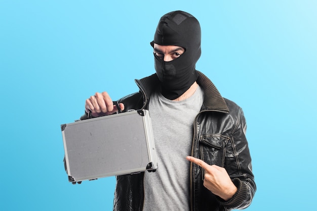 Robber holding a briefcase on colorful background