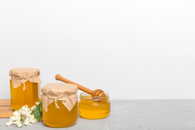 Robinia honey bollte with acacia blossoms on colored table