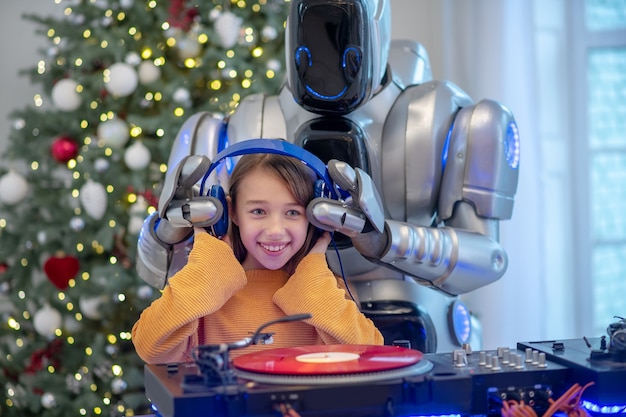 Robot listening to music standing next to the dj table