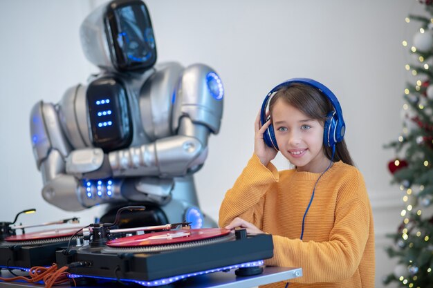 Robot listening to music standing next to the dj table