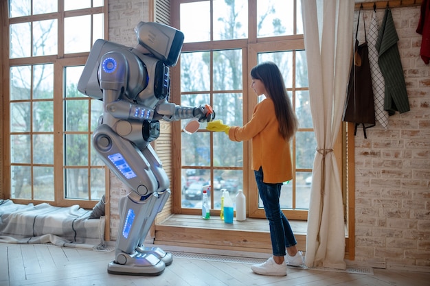 Photo robot spraying liquid for cleaning on the sponge