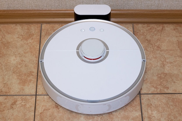 Robot vacuum cleaner on the charging dock after the finished cleaning of the room