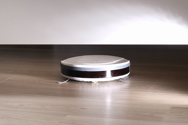 The robot vacuum cleaner cleans under the bed.