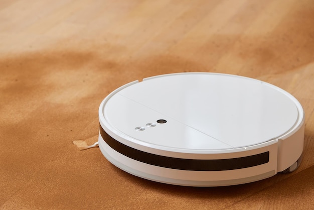 Robot vacuum cleaner cleans the very dirty dusty floor of the apartment at a certain time