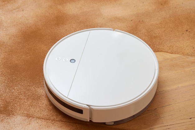 Robot vacuum cleaner cleans the very dirty dusty floor of the apartment at a certain time