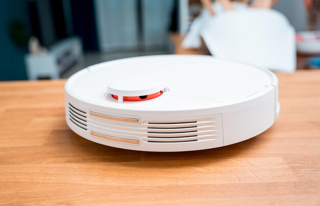 A robot vacuum cleaner at home moving towards the charging station