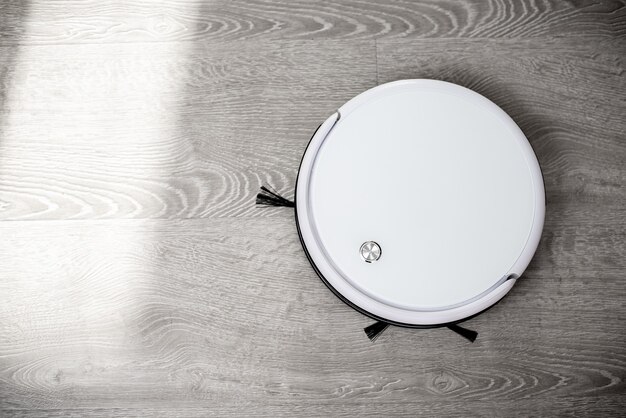 Photo robot vacuum cleaner on laminate floor cleans new cleaning and cleaning technologies