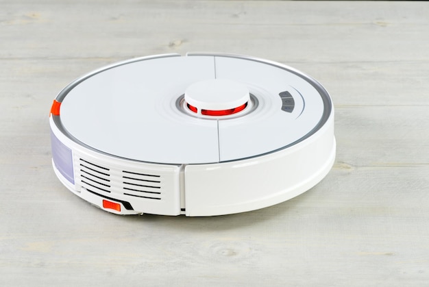 Robot vacuum cleaner on the wooden floor cleaning the room Smart cleaning and washing technology advanced robot work to vacuum then mop