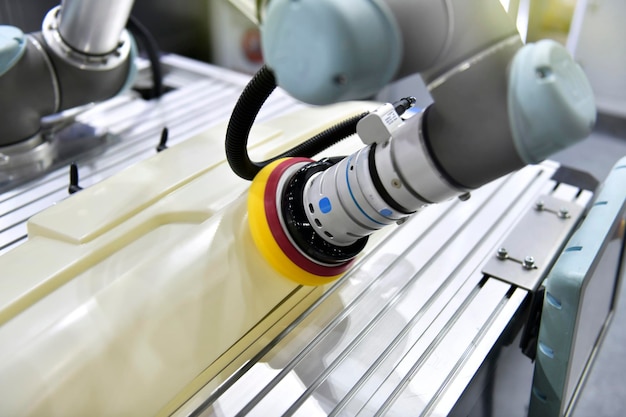 Robotic arm polishing the automotive car part in the production line.