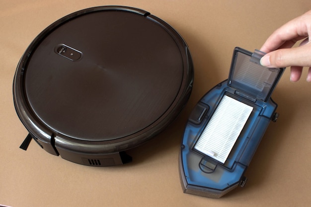 Robotic vacuum cleaner on floor, smart cleaning technology, cleaning the dirt container.