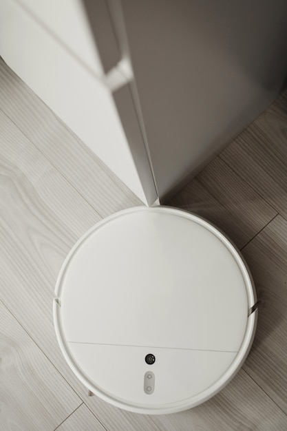 robotic vacuum cleaner on laminate wood floor in living room. vacuum cleaner for daily cleaning