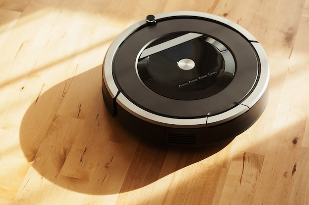 Photo robotic vacuum cleaner on laminate wood floor