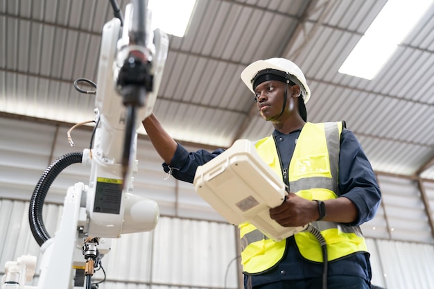 Robotica-ingenieur bezig met onderhoud van moderne robotarm in fabrieksmagazijn Zakelijke technoloy