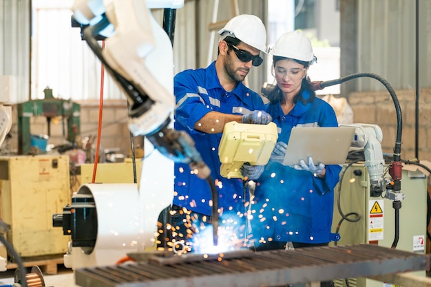 Robotica-ingenieur bezig met onderhoud van moderne robotarm in fabrieksmagazijn