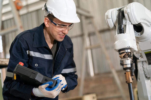 Robotica-ingenieur bezig met onderhoud van moderne robotarm in fabrieksmagazijn