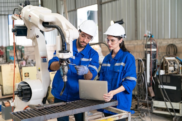 Robotica-ingenieur bezig met onderhoud van moderne robotarm in fabrieksmagazijn