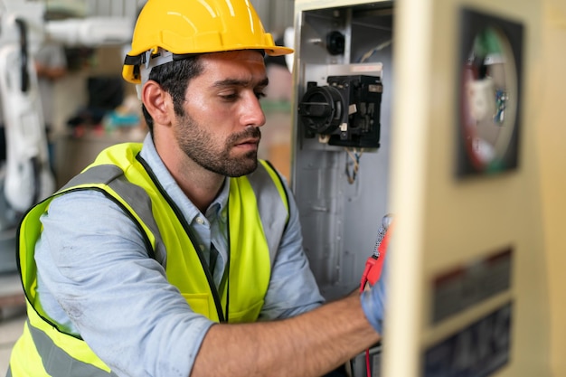 Robotica-ingenieur bezig met onderhoud van moderne robotarm in fabrieksmagazijn