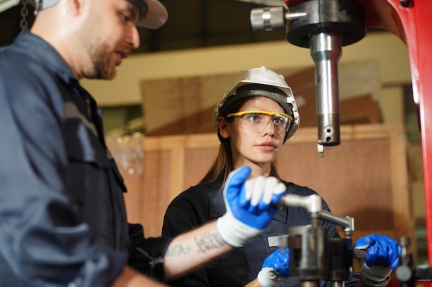 Photo robotics engineer working on maintenance of modern robotic arm in factory warehouse business technoloy