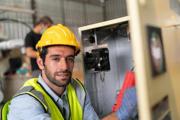 Robotics engineer working on maintenance of modern robotic arm in factory warehouse