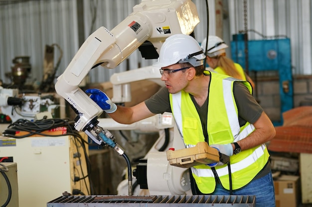 Robotics engineer working on maintenance of modern robotic arm\
in factory warehouse