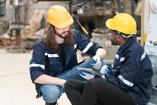 Robotics engineer working on maintenance of modern robotic arm in factory warehouse