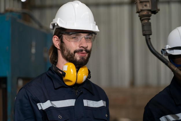 Robotics engineer working on maintenance of modern robotic arm in factory warehouse