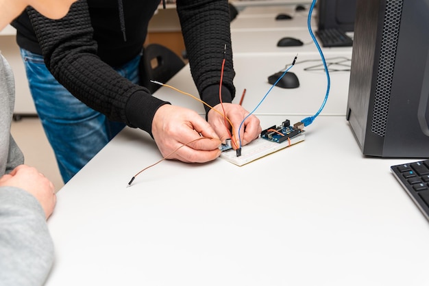 Robotics Man makes a robot Modern technologies Development of automated technical systems A mechanic is assembling a robot Closeup Stem Concept