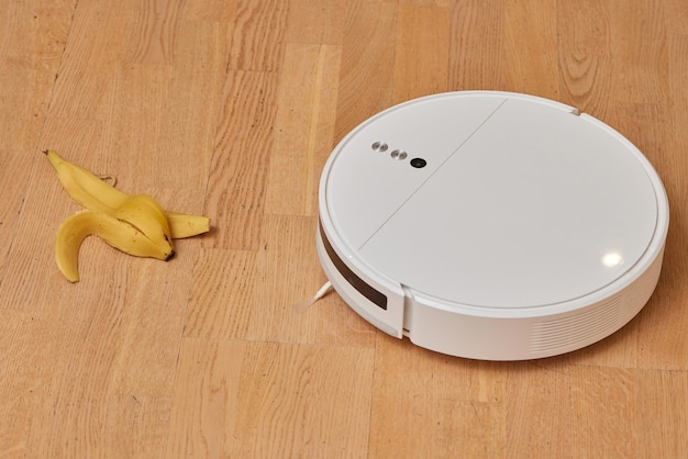 Robotstofzuiger op laminaat houten vloer slimme reinigingstechnologie banaan