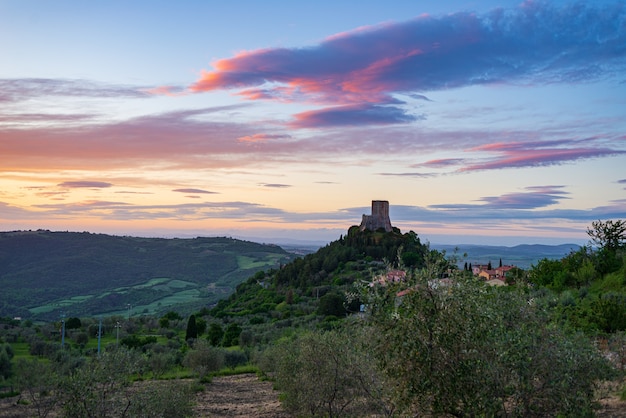 로카 도르시아(Rocca dOrcia) 중세 마을과 오르시아 밸리 투스카니 이탈리아(Orcia Valley Tuscany Italy)의 요새 황혼의 독특한 전망 석탑은 극적인 하늘을 배경으로 바위 절벽에 자리 잡고 있습니다.