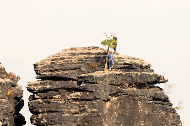 The rock against the sky with the climbers on the surface