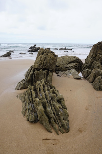 Rock on beach against sky