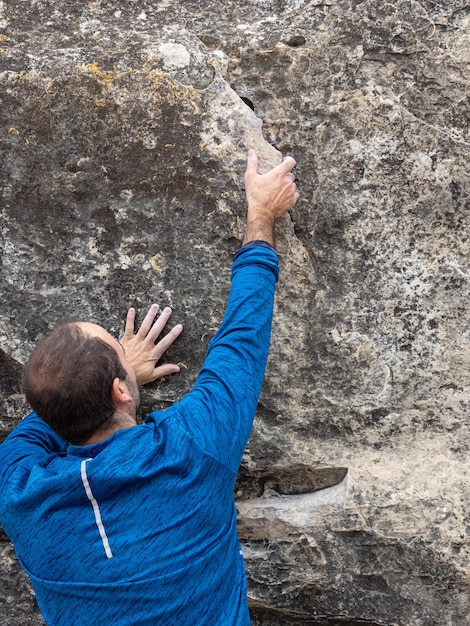 Rock climber bouldering outdoors on mountain in nature