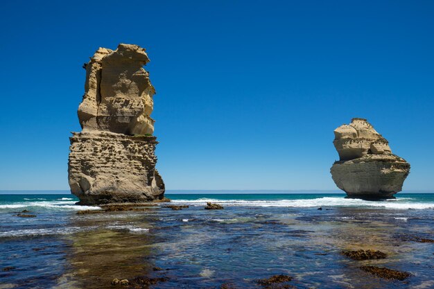 Rock formation on beach against clear blue sky