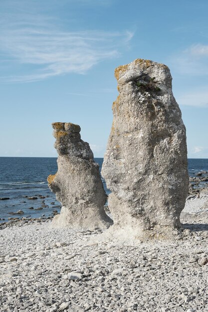 Rock formation on beach against sky