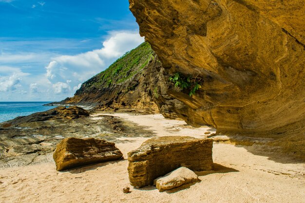 Rock formation on beach against sky