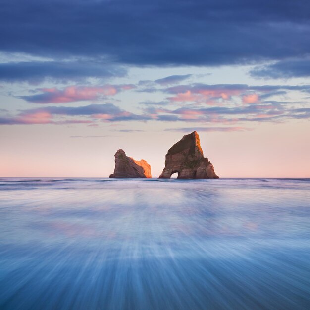 Photo rock formation in sea against sky during sunset