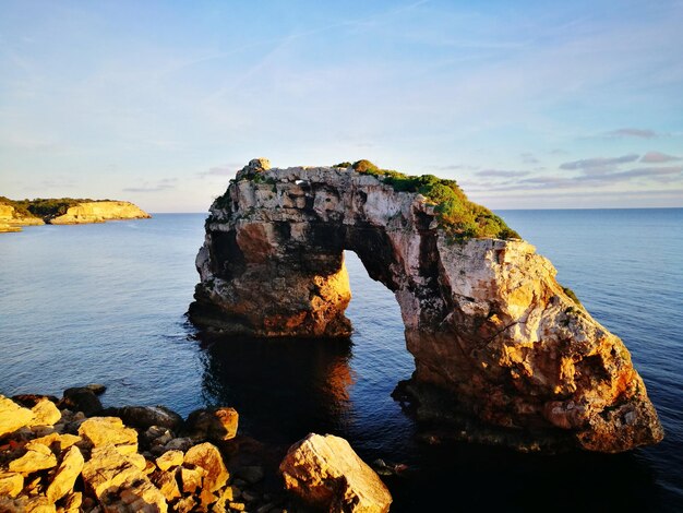 Rock formation in sea against sky