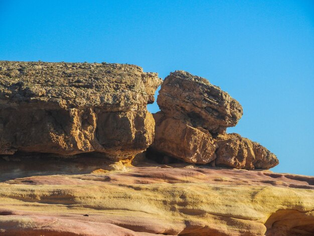 Rock formations against clear blue sky