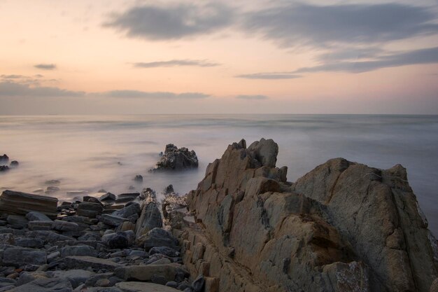 rock formations in the beach under the sunset light