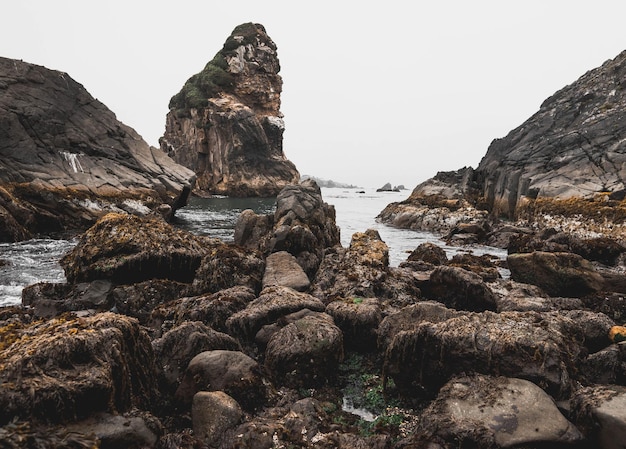 Rock formations by sea against clear sky