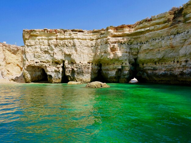 Rock formations by sea against sky