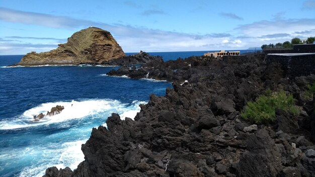 Rock formations by sea against sky