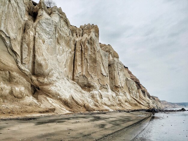 Каменные образования на море на фоне неба