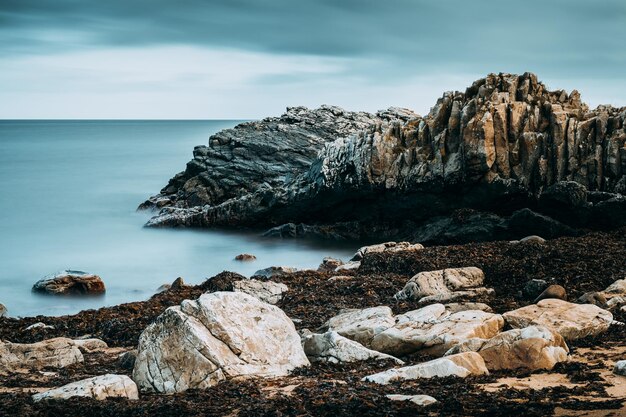 Rock formations by sea against sky