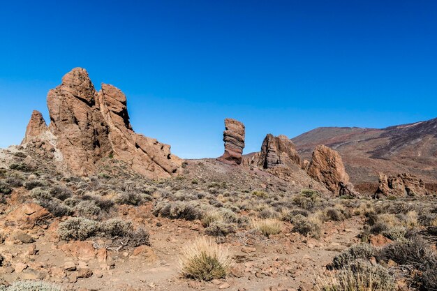 Rock formations on mountain against clear blue sky